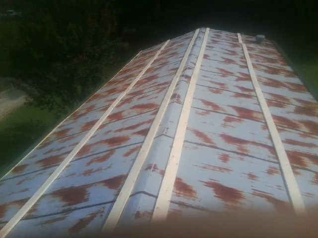 Rusted metal roof panels with new wood purlins before replacement — Storm Damage Roof Repair in Temperanceville by Roofing Brothers